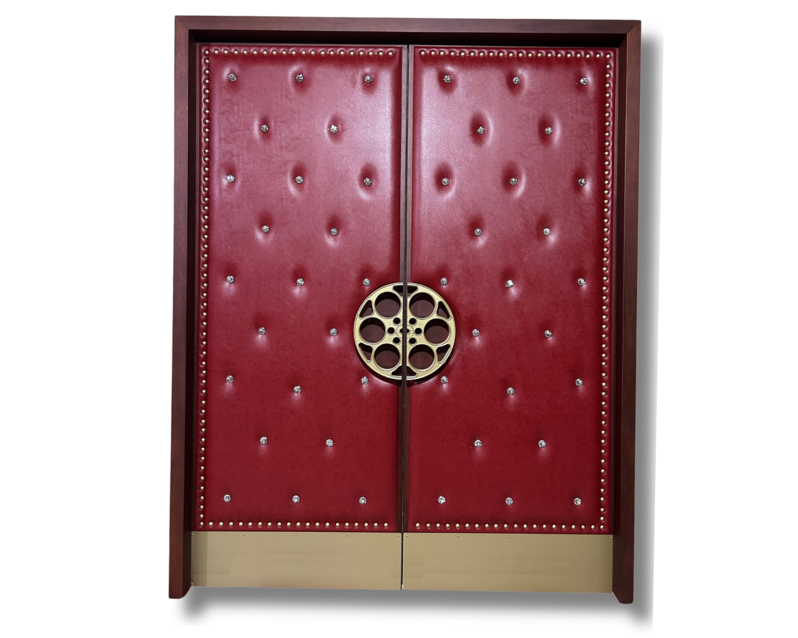 Custom upholstered double home theater doors with crimson red tufted leather-look vinyl, decorative gold rivets, and a vintage brass film reel handle