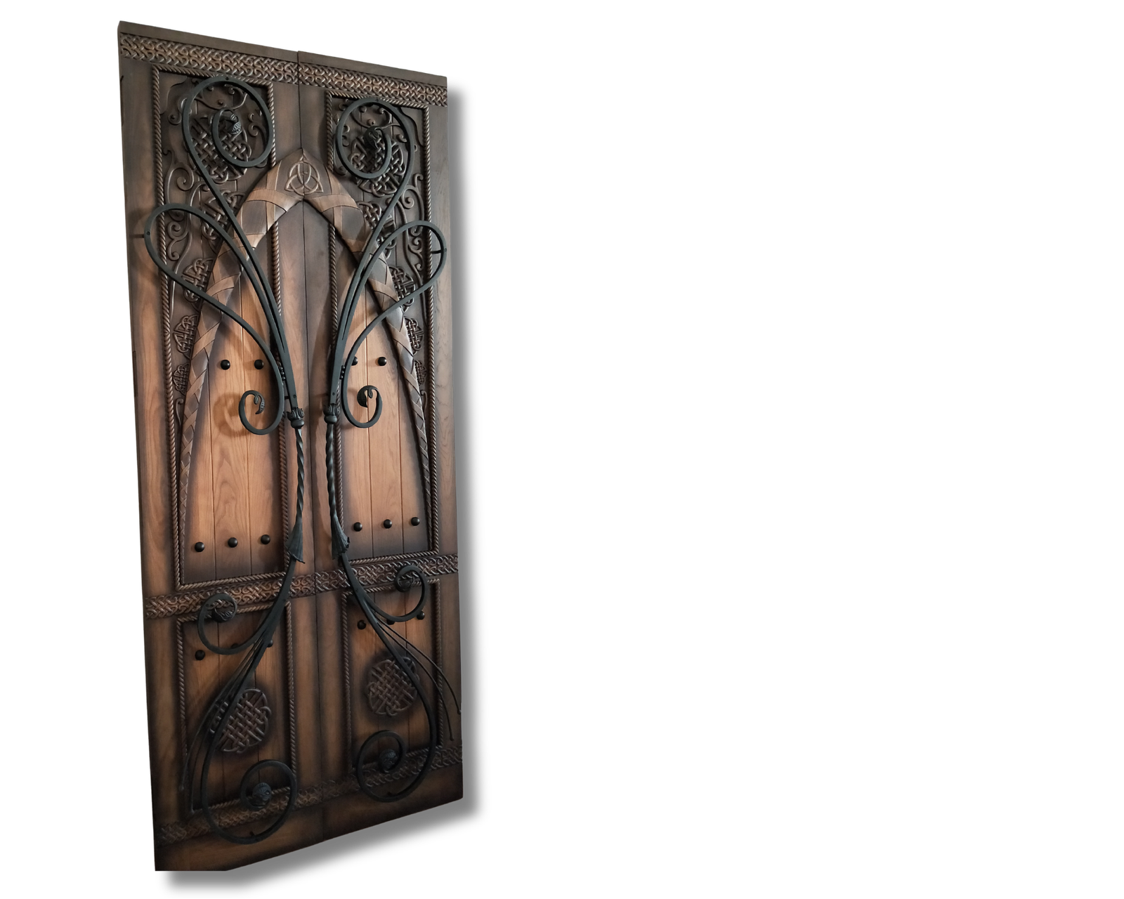 Dual-tone wood double doors with hand-carved Celtic knot designs, a central Triquetra symbol, and large decorative black wrought iron scrollwork