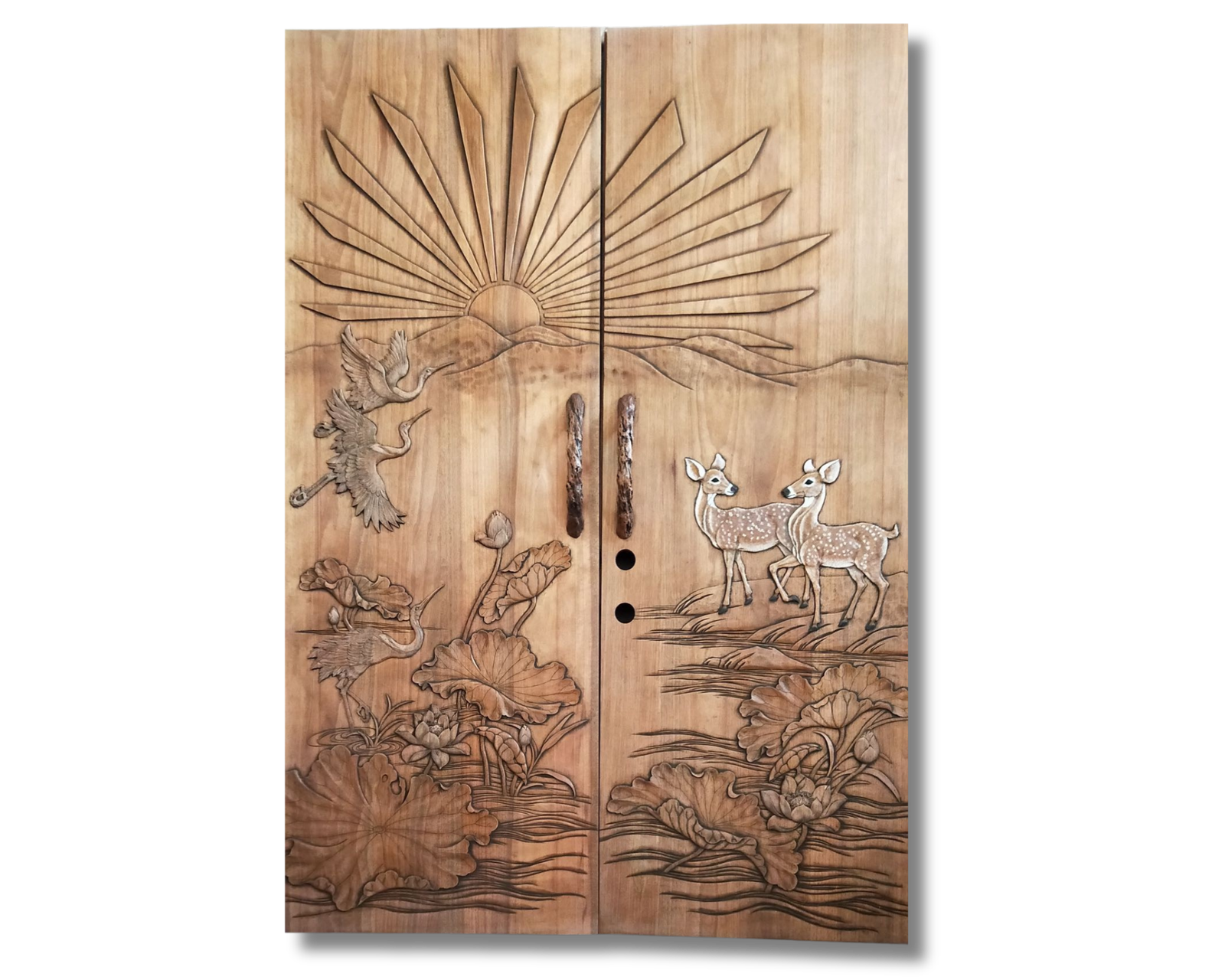 Full studio view of a solid wood double entry door by Crown Custom Doors, featuring intricate hand carvings of lotus flowers, flying cranes, spotted deer, custom branch handles, and a rising sunburst over mountain peaks.