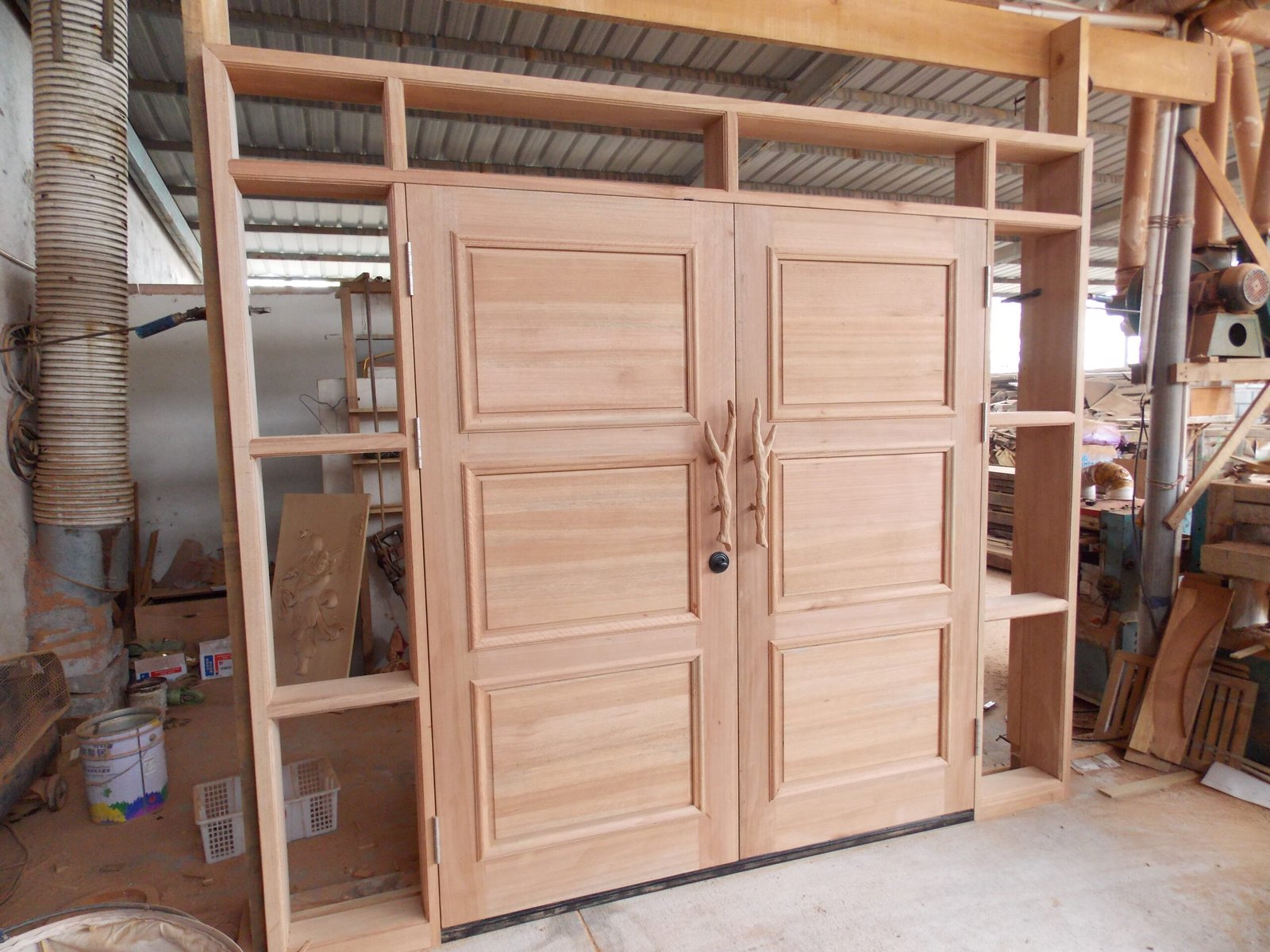 Interior back view of a custom solid wood double entry door featuring classic 3-panel construction, custom branch handles, heavy-duty hinges, and an integrated sidelight and transom jamb frame pre-assembled by Crown Custom Doors.