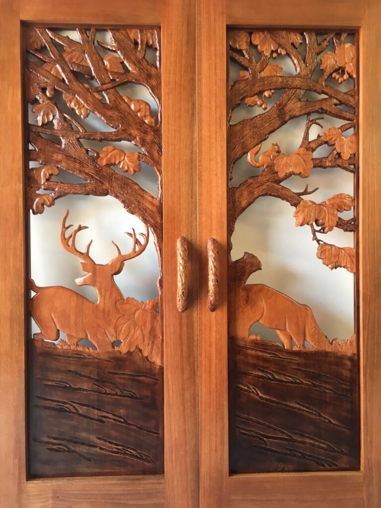 Interior view of a custom hand-carved solid wood double front door showcasing the smooth backside finish, deer silhouette relief, oak branches, and custom hand-carved branch door handles.