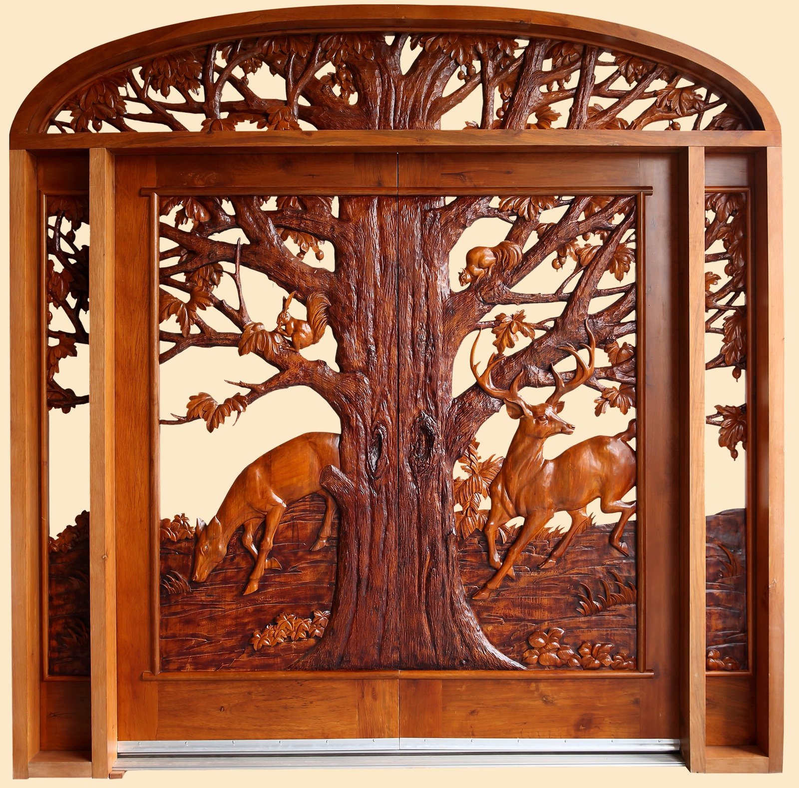 A front view of a finished, stained solid wood double entry door system featuring detailed 3D hand carvings of a buck and doe under a large oak tree with squirrels, fully integrated with matching open-carved sidelights and a massive decorative arched transom top.