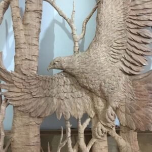 Extreme close-up shot of hand-carved solid mahogany bald eagle feathers and birch tree bark texture in progress for a custom front door panel.