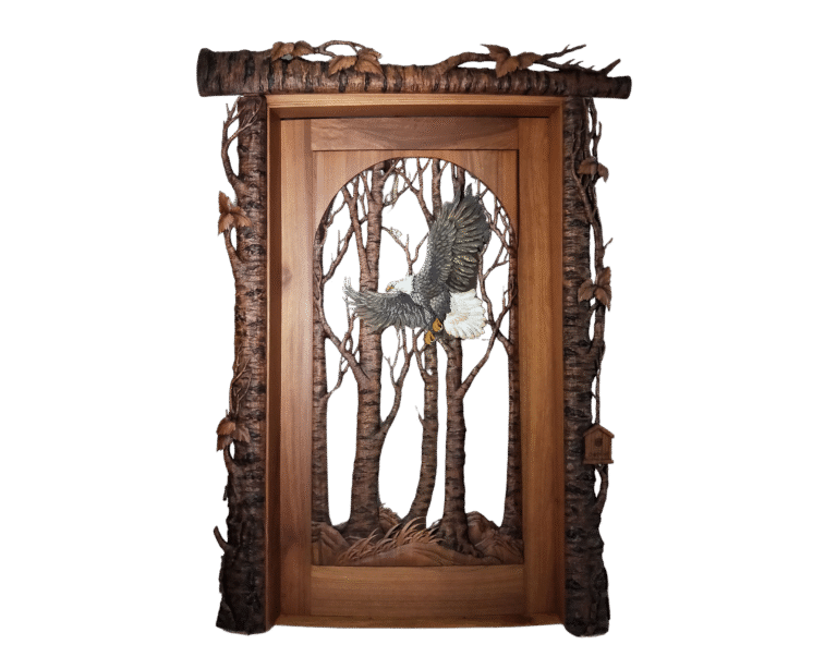 Handcrafted wooden door featuring a detailed carved bald eagle in flight through a forest of trees, framed with rustic log-style bark and leaf accents, custom made by Crown Custom Doors