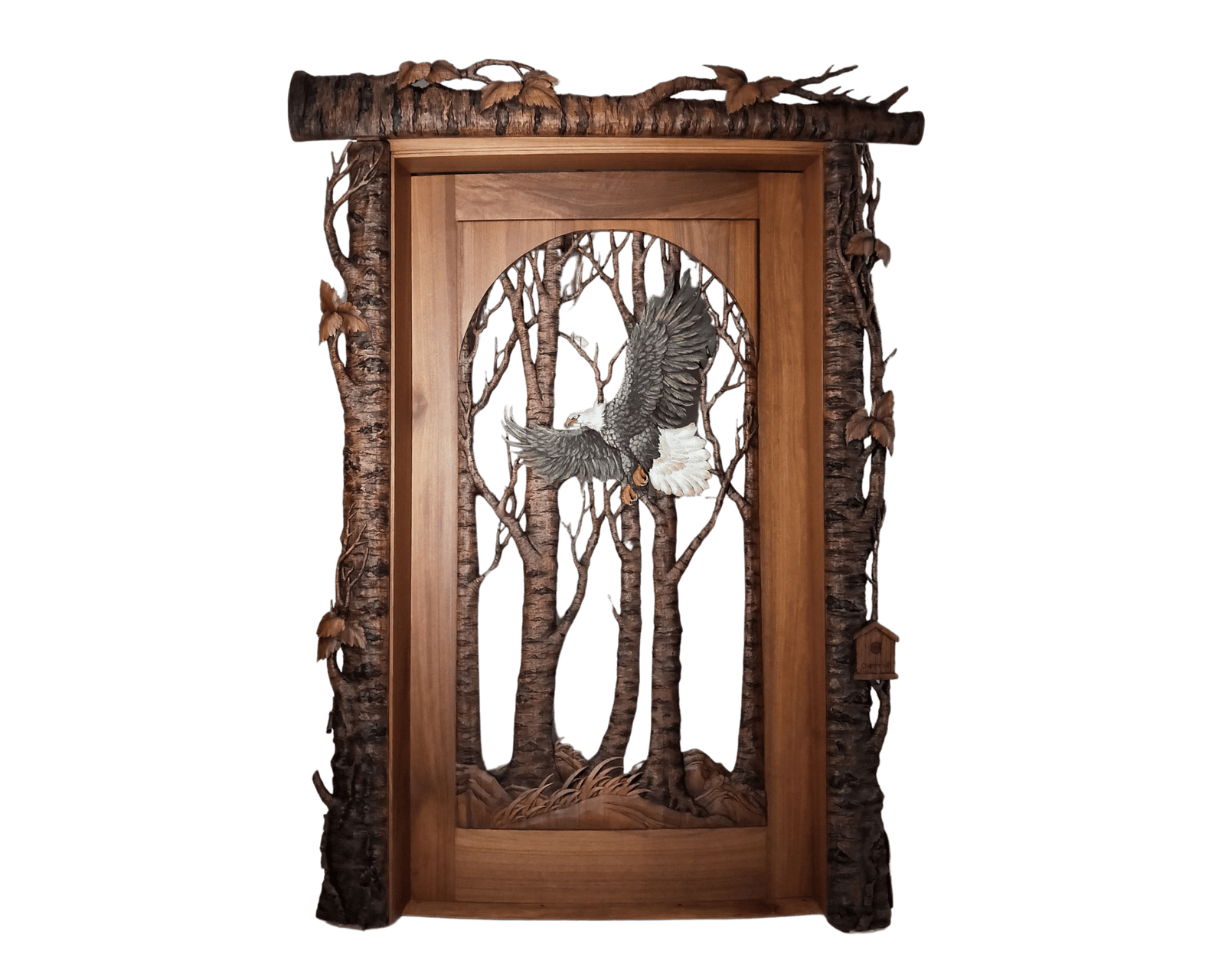 Handcrafted wooden door featuring a detailed carved bald eagle in flight through a forest of trees, framed with rustic log-style bark and leaf accents, custom made by Crown Custom Doors