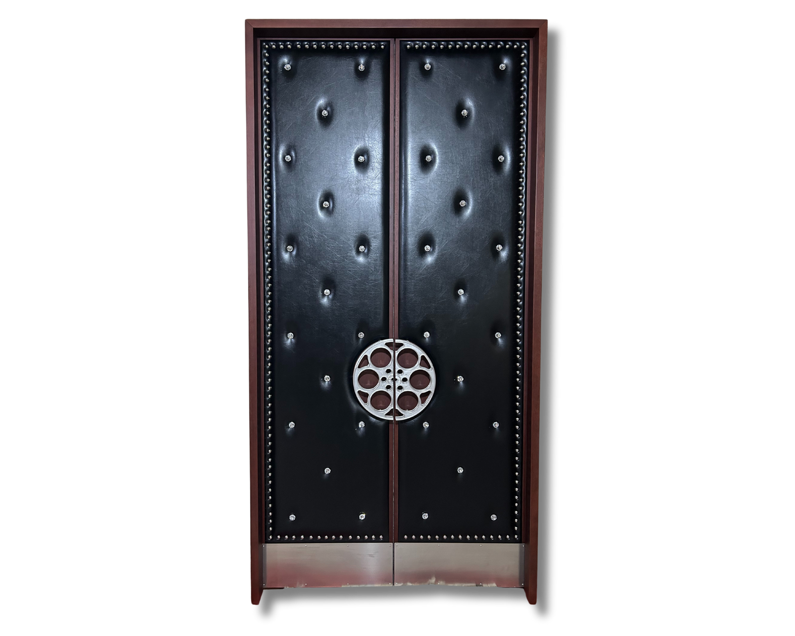 A premium custom home cinema double door system by Crown Custom Doors, featuring sleek black upholstered acoustic vinyl panels with diamond-tufted crystal studs, chrome nailhead border trim, a polished wood outer frame, a silver film reel pull handle, and integrated stainless steel kickplates.