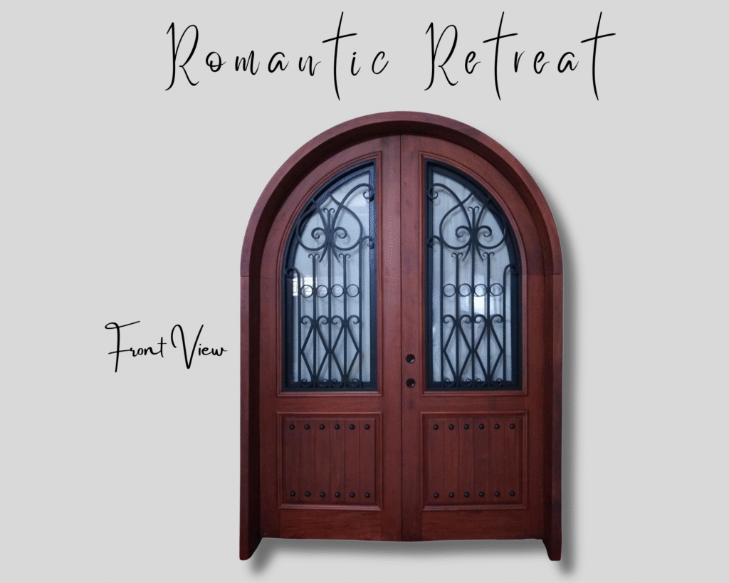 A direct front view of the "Romantic Retreat" custom arched double entry door handcrafted from warm solid mahogany wood, featuring rustic vertical-plank bottom panels detailed with black decorative clavos and arched glass window inserts with hand-forged black wrought iron scrollwork.