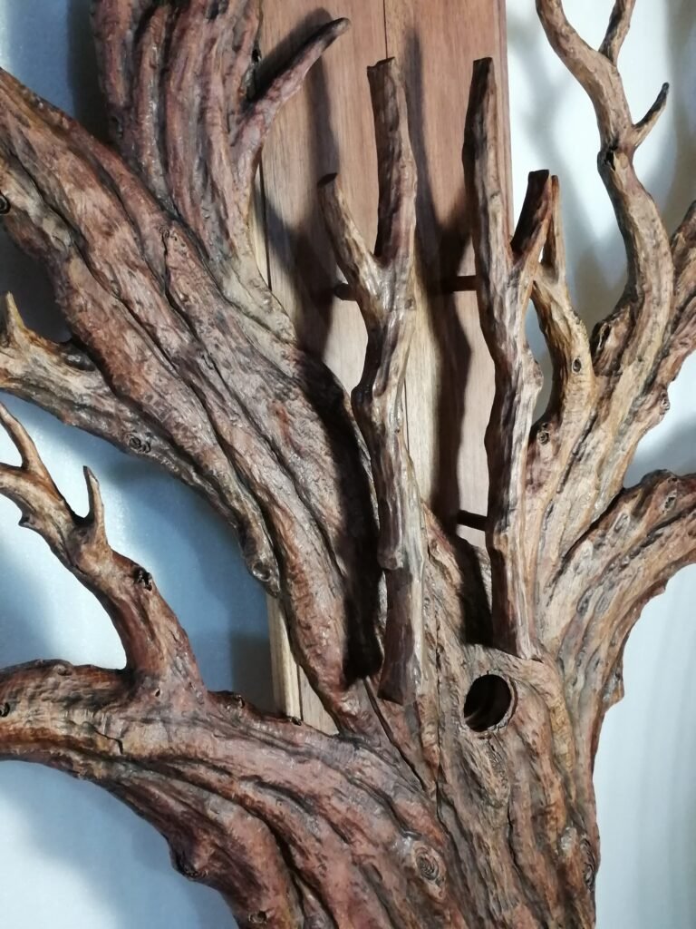Close-up side-angle view of a solid wood door carving showcasing deeply sculpted tree bark textures, spreading branches, and layered wood elements held by concealed pins to create multi-dimensional relief depth.
