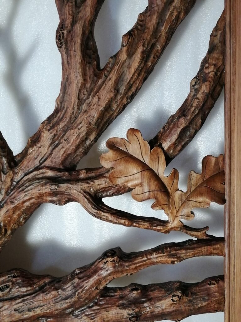 Close-up of finished solid wood door panel with detailed hand-carved oak leaves, deep branch contours, and warm wood stain.