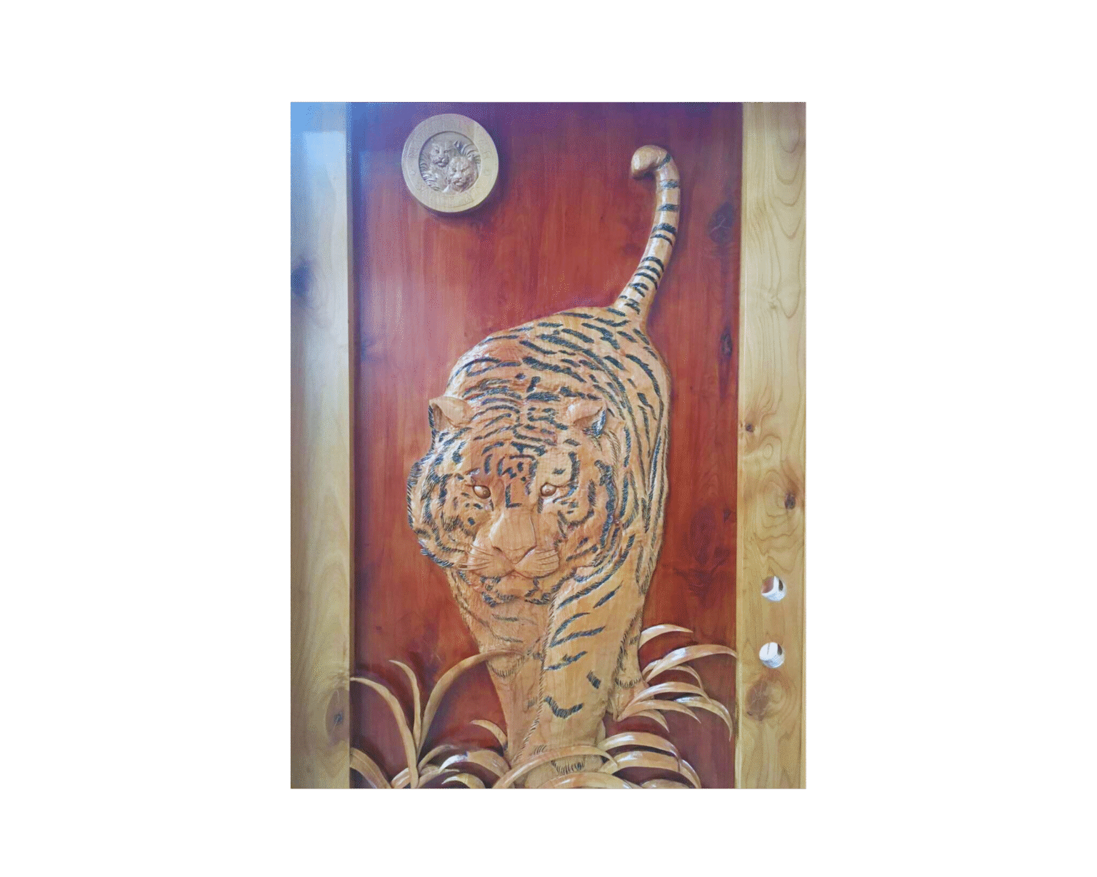 Detailed close-up of a custom hand-carved solid wood entry door titled Tiger's Gaze, featuring a 3D relief carving of a tiger walking through tall grass with an official sanctuary emblem seal, crafted by Crown Custom Doors.