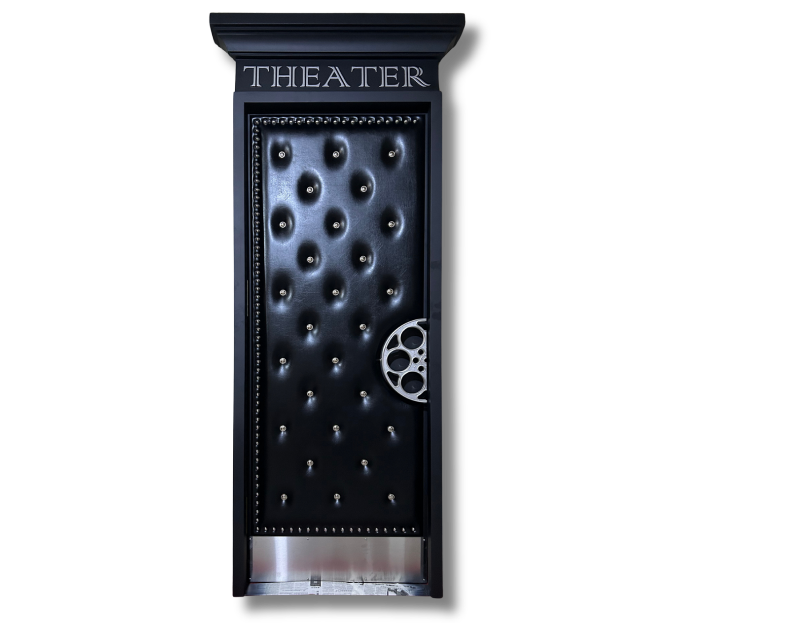 Custom handcrafted acoustic home theater door featuring diamond-tufted black leather upholstery, silver button tufting, an engraved THEATER marquee casing, and a custom silver film reel door pull handle set against a black background by Crown Custom Doors.
