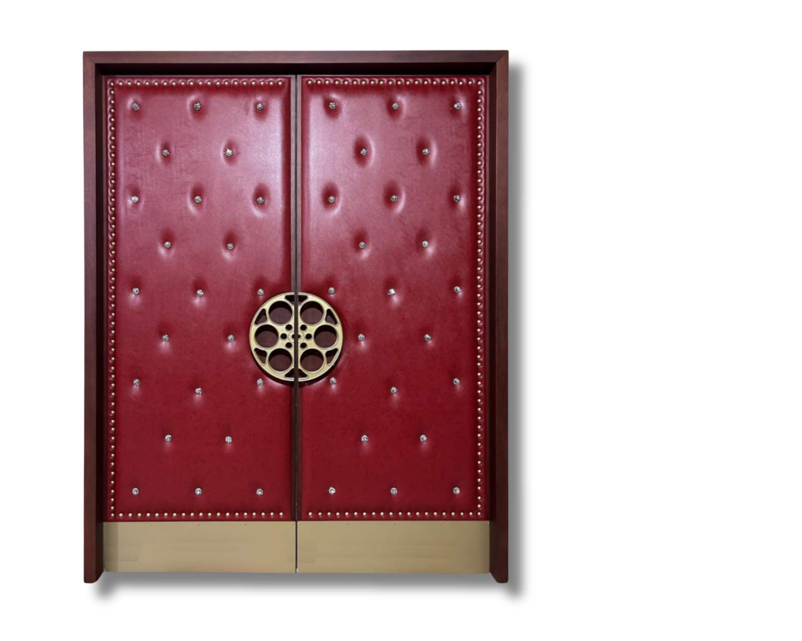 Custom acoustic home theater double doors upholstered in burgundy red diamond-tufted leather with crystal buttons, gold stud border trim, gold film reel center handles, and a brass kick plate.