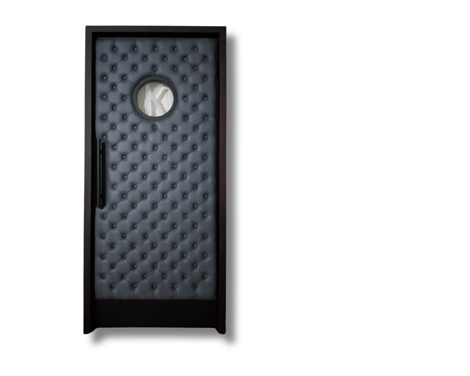 Custom soundproof home theater door featuring deep charcoal gray diamond button-tufted leather upholstery, a dark wood frame, a round porthole vision window, and a sleek matte black vertical pull handle.