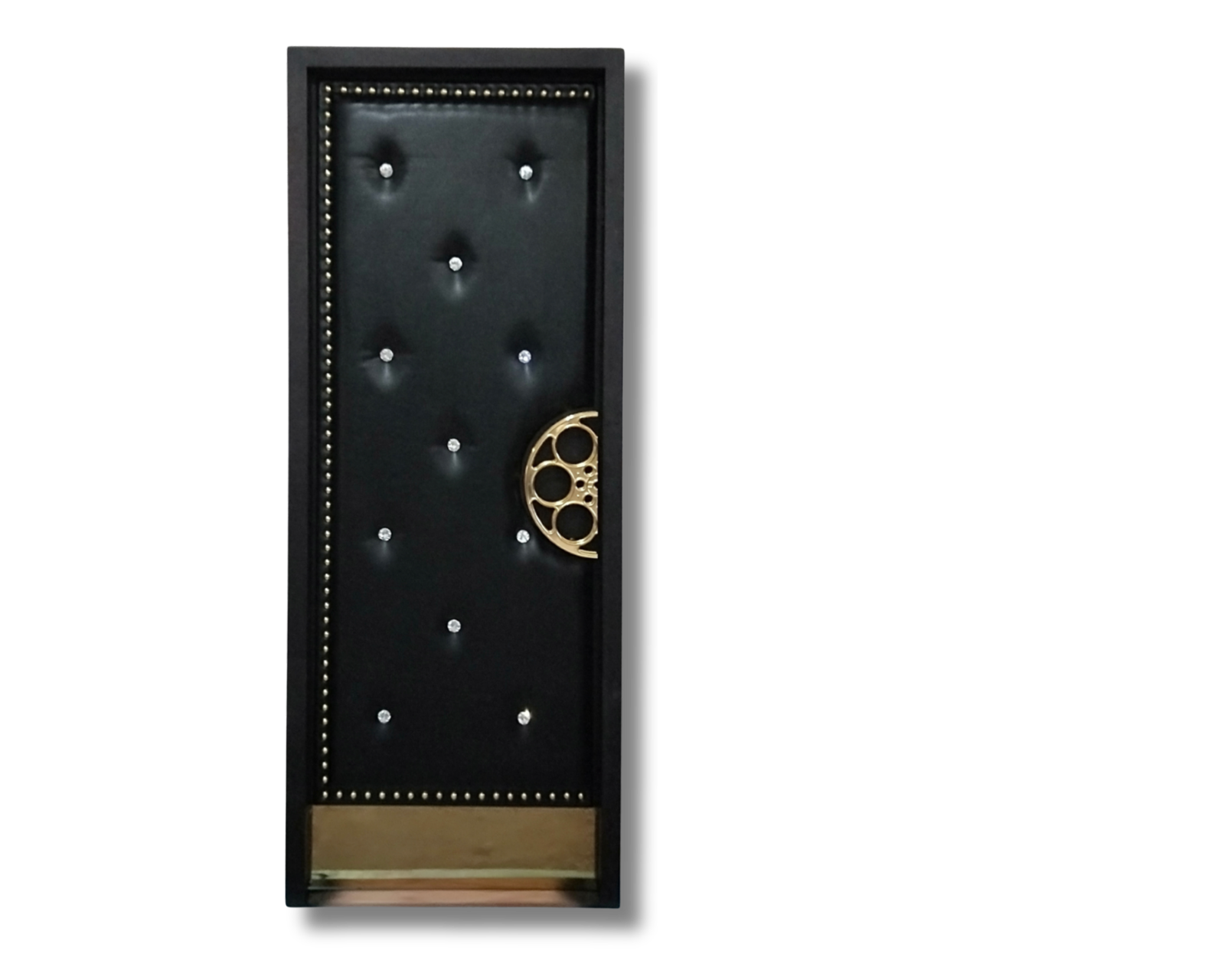 Custom acoustic home theater door crafted with diamond-tufted black leather upholstery, crystal buttons, perimeter metallic studs, a brass kick plate, and a signature brass film reel handle by CROWNCUSTOMDOORS.