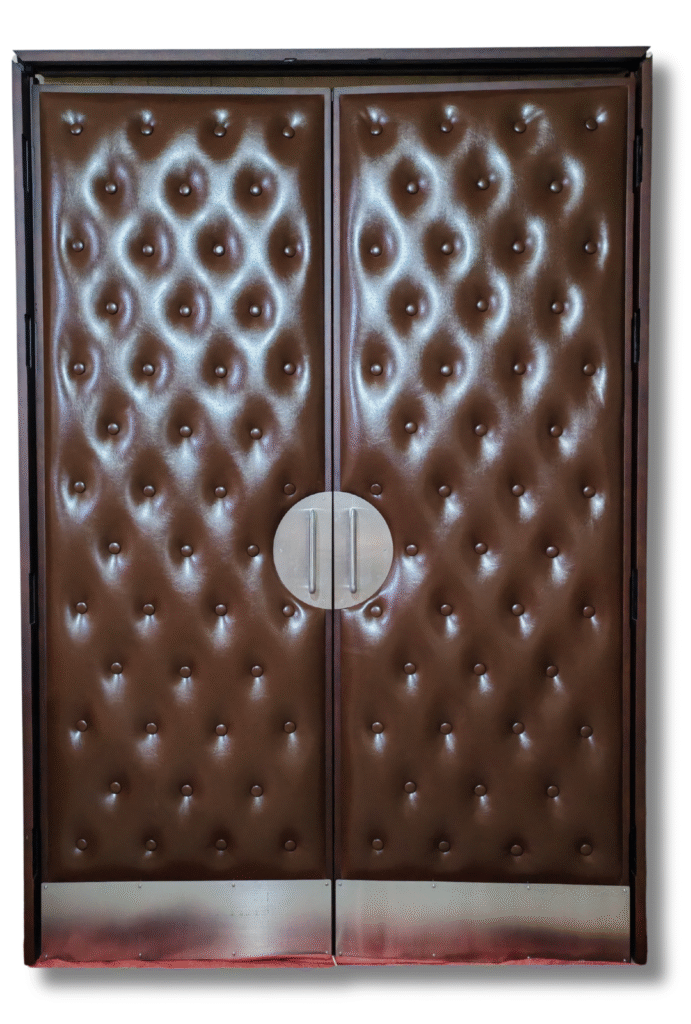 Front view of custom chestnut brown tufted leather double doors for a home theater, featuring a dark wood frame, circular brushed nickel push-pull handles, and brushed metal kickplates.