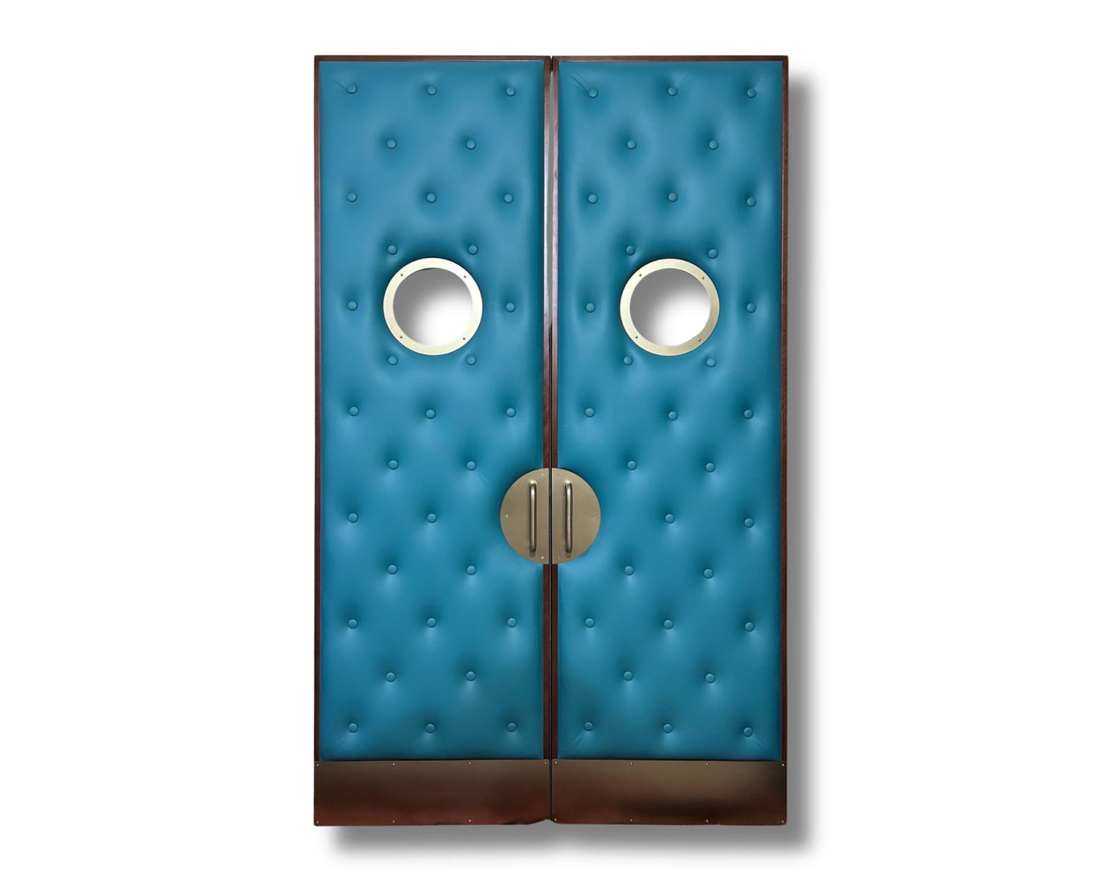 Custom teal blue tufted vinyl upholstered acoustic double doors for a home theater featuring circular glass porthole windows, brass kick plates, and round matte brass pull handles on a black background.