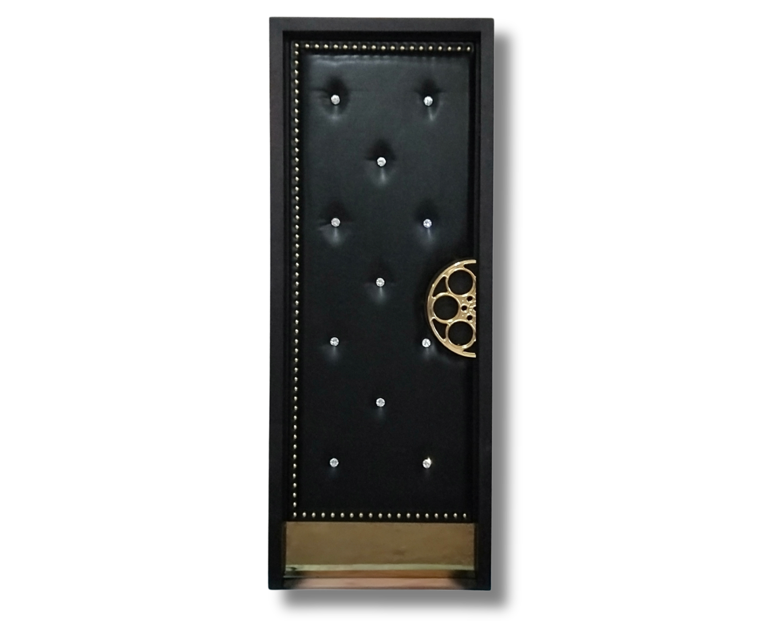 Custom soundproof home theater door in black tufted leather-look finish featuring crystal button tufting, gold stud trim, and a gold film reel pull handle.