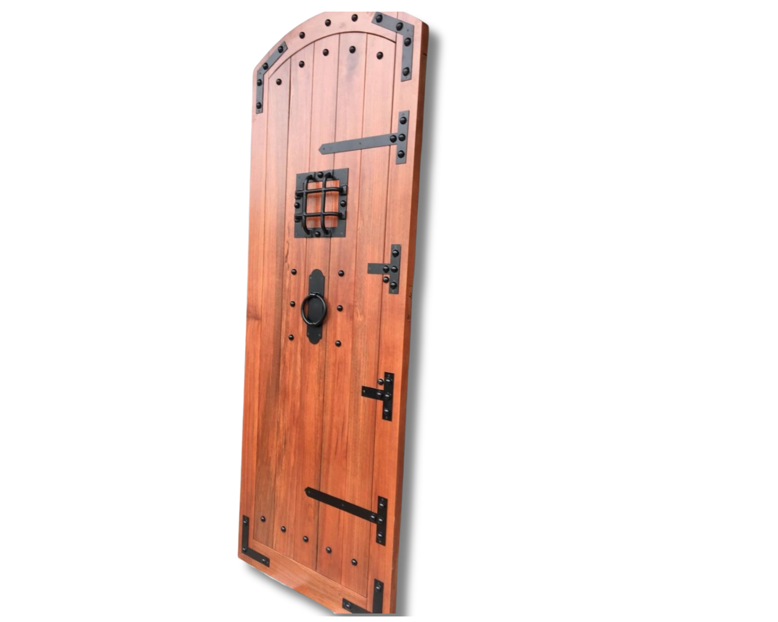 Solid wood arched entry door with custom warm mahogany stain finish, decorative wrought iron strap hinges, iron clavos studs, ring knocker, and small speakeasy iron grille window.